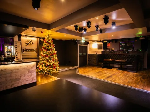Decorated Christmas tree in red and gold next to the bar at Hidden Burnley.