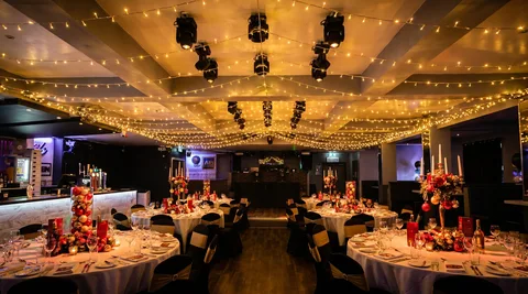 PAR-can ceiling at Hidden Burnley criss-crossed with warm-white fairy lights, dressed for a Christmas dinner.