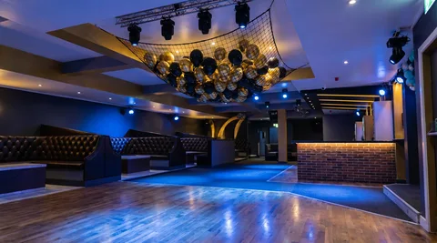 Black-and-gold balloon drop suspended above the dance floor at Hidden Burnley ready for the New Year countdown.