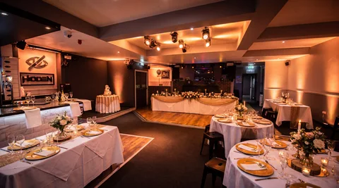 Hidden Burnley dressed for a wedding reception with white linens and warm uplighting.