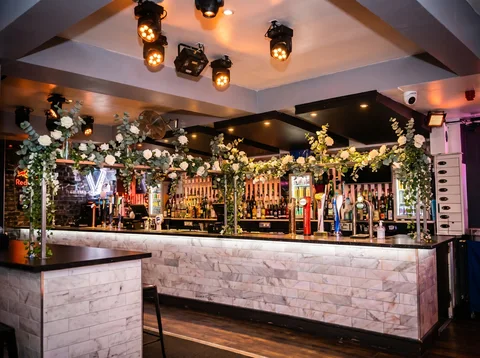 Bar at Hidden Burnley dressed for a wedding with white roses, eucalyptus and trailing greenery.