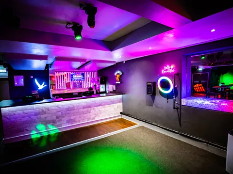 Dance floor at Hidden Burnley with cyan and magenta uplighting and logo gobo projections.