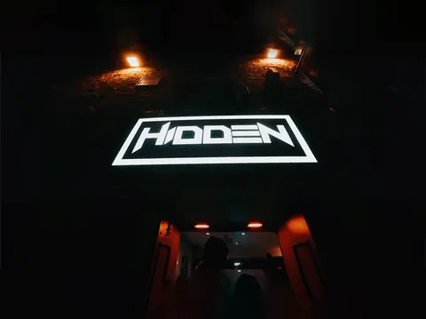 Hidden Burnley exterior at night with the illuminated HIDDEN sign over the entrance.